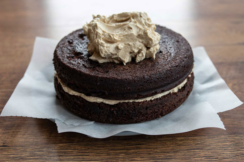 assembling chocolate cake with coffee frosting