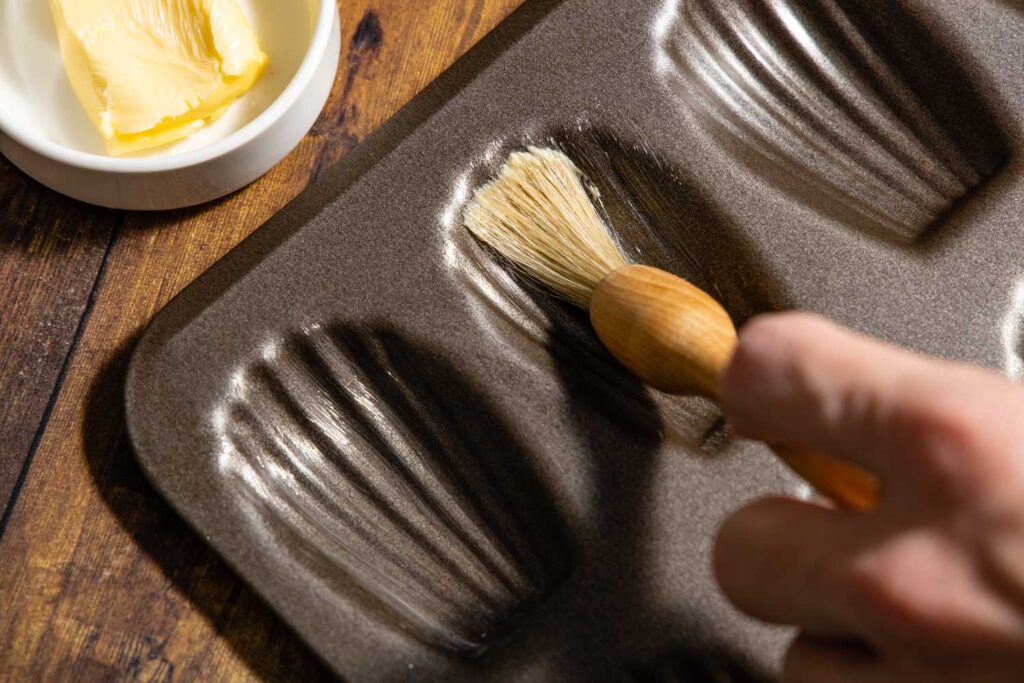 buttering a madeleine pan
