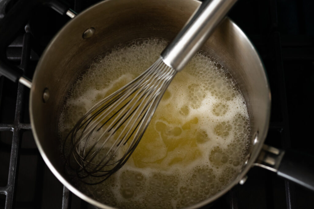 Water, butter, sugar, and salt mixture boiling on the stove