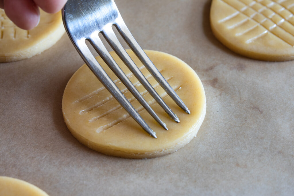 using the tines of a fork to create a crosshatch pattern on the sable cookies