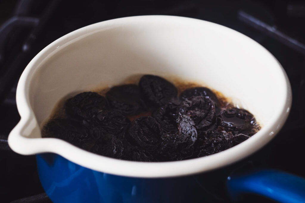 prunes cooking in brandy in a pan on a stove