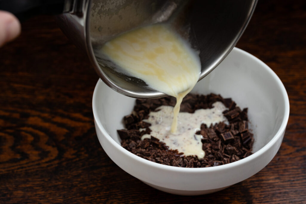 pouring hot cream over chocolate to make ganache