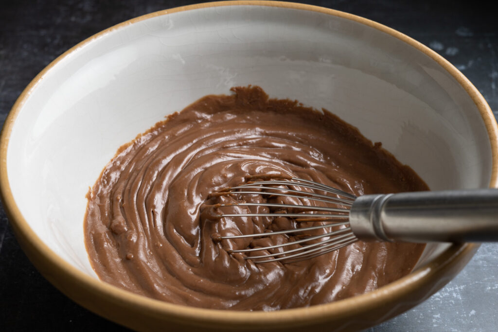 chocolate pastry cream in a mixing bowl with a whisk