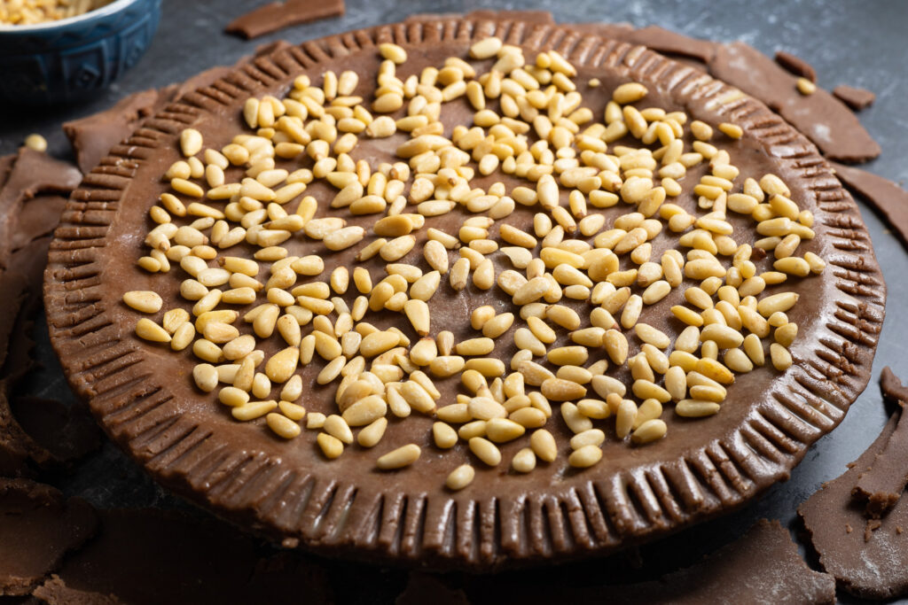 pine nuts scattered on the top of the chocolate torta della nonna