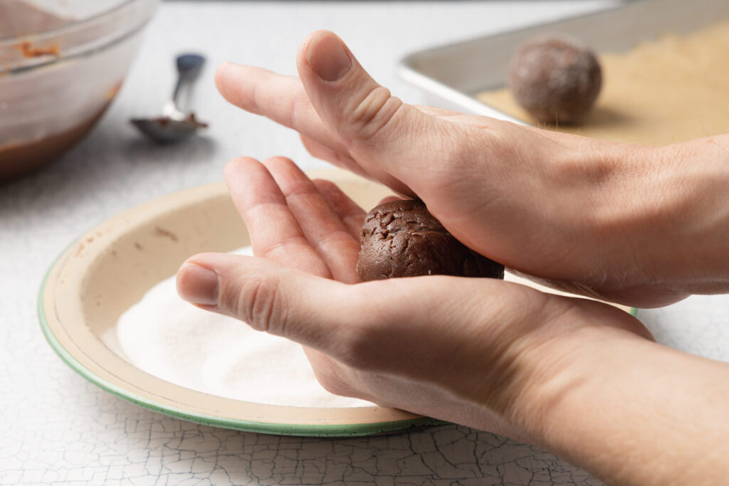 using hands to roll chocolate buckwheat cookie dough into balls