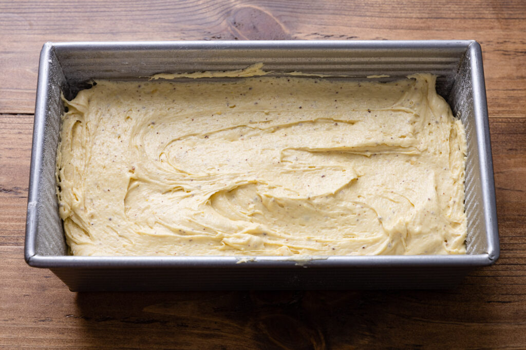 the cake batter in the greased loaf pan ready for baking