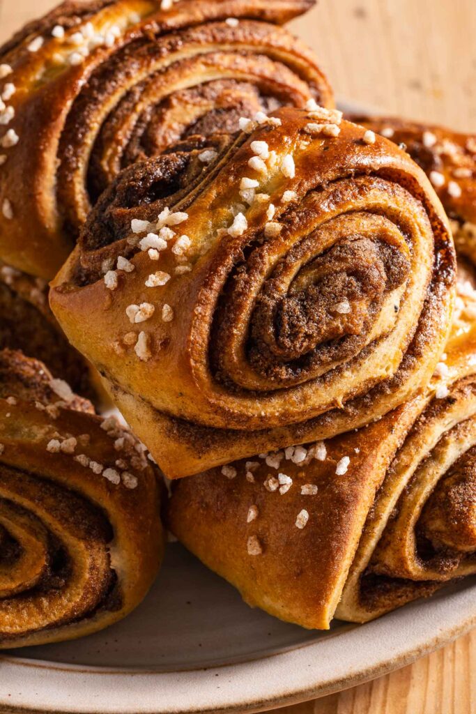 Korvapuusti cinnamon buns stacked on a white ceramic plate