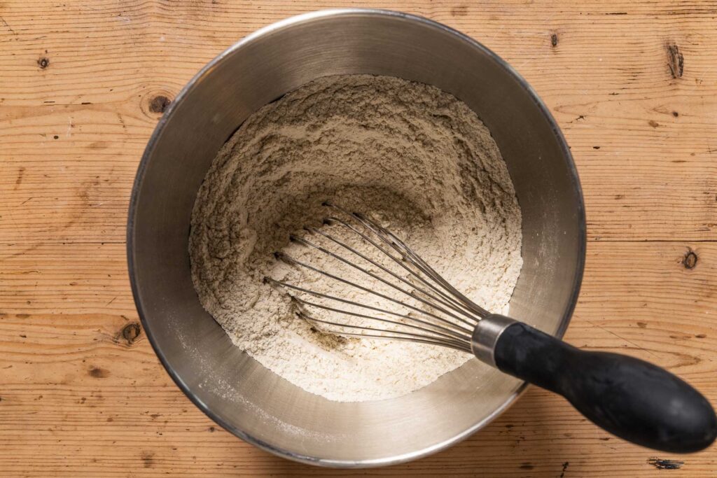 An overhead photo of the dry ingredients whisked together in a mixing bowl with a whisk