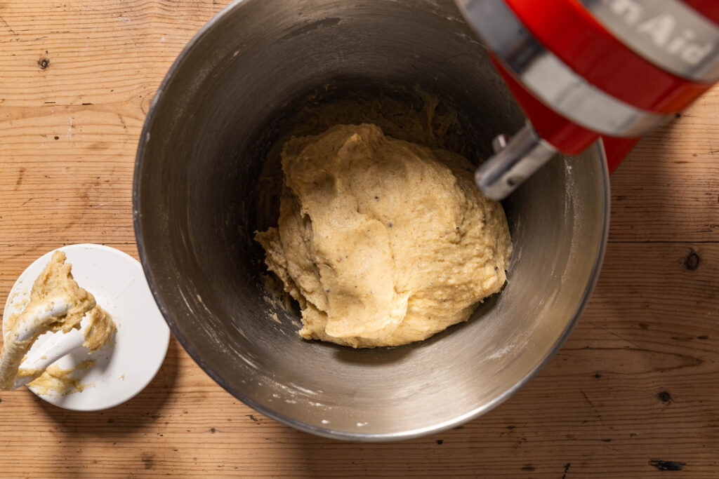 An overhead shot of the cinnamon bun dough in a stand mixer after kneading