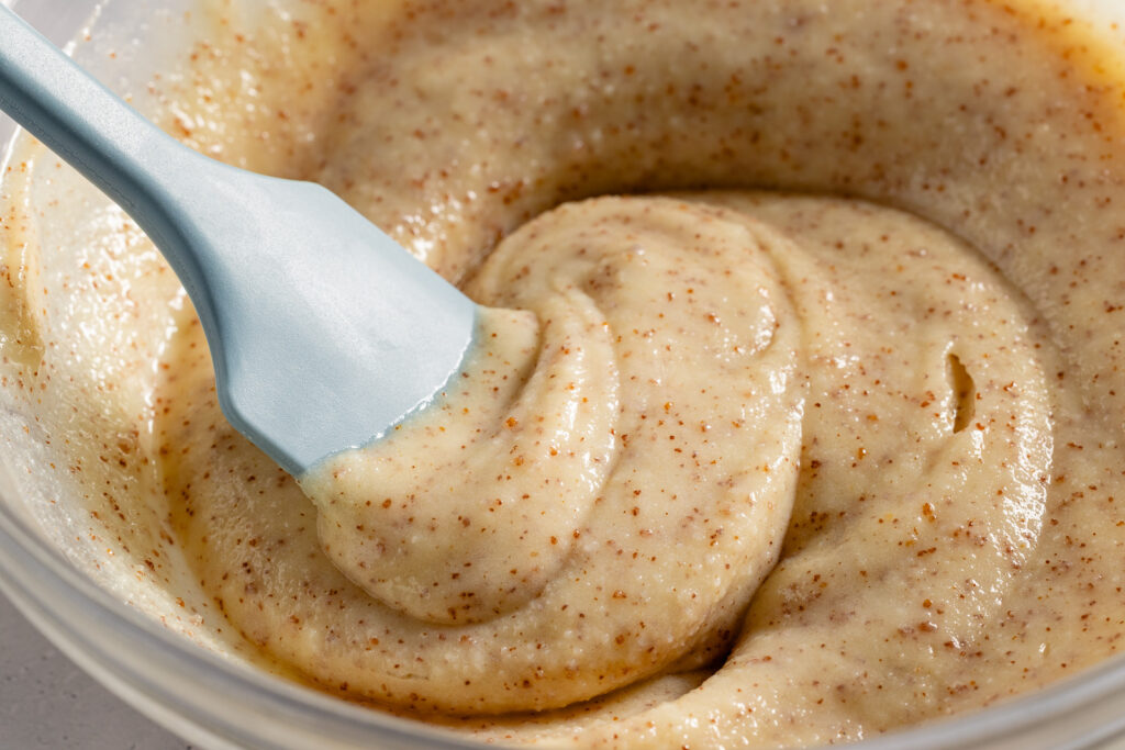 Softened re-solidified brown butter in a glass bowl with spatula