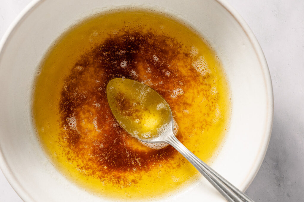 Brown butter in a white bowl with a spoon