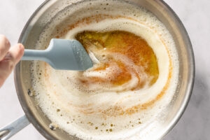 Stirring brown butter with a spatula in a sauté pan